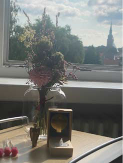 Tisch mit Blumenstrauß vor einem Fenster
